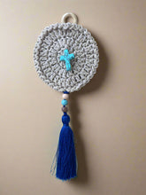 Load image into Gallery viewer, Crocheted round wall hanging with blue tassel and beads on a concrete surface