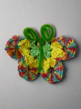 Load image into Gallery viewer, Colorful crocheted butterfly with green leaves on a textured white background