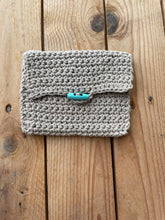 Load image into Gallery viewer, Knitted pouch with a button on a wooden surface