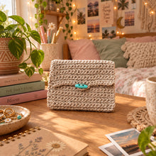 Load image into Gallery viewer, Knitted pouch with a button on a wooden surface