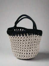 Load image into Gallery viewer, Crocheted bag with black handle on a stone surface