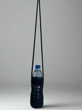 Load image into Gallery viewer, Black knitted bottle holder with a water bottle on a gray background