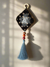 Load image into Gallery viewer, Decorative wall hanging with a crochet design, beads, and a tassel on a neutral background