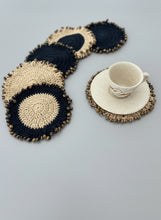 Load image into Gallery viewer, Set of crocheted coasters with a cup on a wooden surface