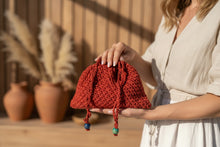 Load image into Gallery viewer, Red knitted bag with blue and green beads on a concrete surface