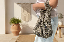 Load image into Gallery viewer, Person holding a woven bag in the living room