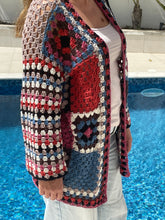 Load image into Gallery viewer, Person wearing a colorful crochet jacket by a pool