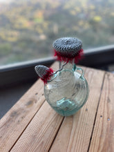 Load image into Gallery viewer, Decorative glass bottle with a knitted cap on a wooden surface
