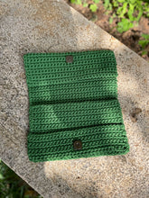 Load image into Gallery viewer, Green knitted pouches with buttons on a stone surface