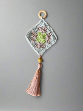 Load image into Gallery viewer, Crocheted wall hanging with a tassel on a gray background