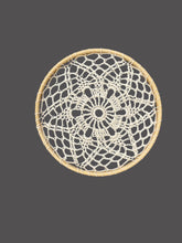 Load image into Gallery viewer, Round woven coaster with a black and white pattern on a gray fabric background