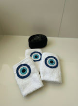 Load image into Gallery viewer, White towels with blue and black eye designs on a white surface