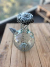 Load image into Gallery viewer, Decorative bottle with a crocheted top on a wooden surface