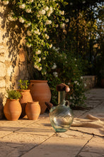 Load image into Gallery viewer, Lebanese Ibriq with a dark brown crochet cover with an acorn in a garden