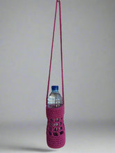 Load image into Gallery viewer, Pink crocheted bottle holder with a water bottle on a gray background