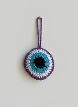 Load image into Gallery viewer, Crocheted eye-shaped pouch with purple, blue, and white colors on a light gray background