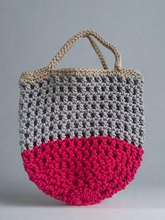 Load image into Gallery viewer, Crocheted bag with two-tone design on a gray background