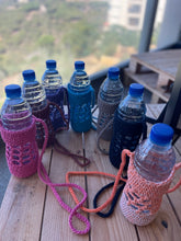 Load image into Gallery viewer, Set of water bottles with colorful knitted covers on a plain background