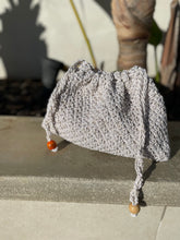 Load image into Gallery viewer, Crocheted bag with wooden beads on a stone surface