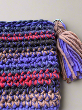 Load image into Gallery viewer, Close-up of a colorful crocheted bag with a tassel on a beige background