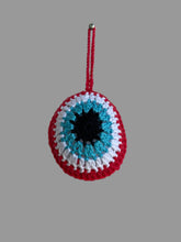 Load image into Gallery viewer, Crocheted eye-shaped pouch with red, blue, and white colors on a light gray background