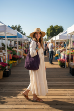 Load image into Gallery viewer, Woman carrying purple raffia crochet bag