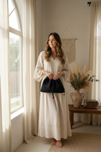 Load image into Gallery viewer, Woman holding black crochet dust bag lifestyle photo