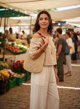 Load image into Gallery viewer, Woman holding Crochet Raffia Bag lifestyle shot
