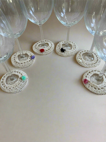 Crocheted drink coasters with colorful pins on a textured surface