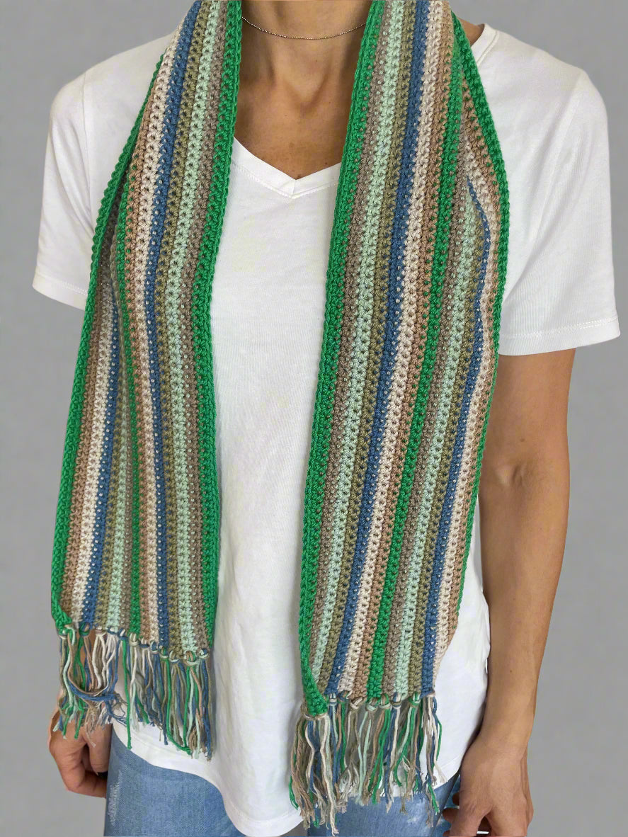 Person holding a striped woven mat with green, brown, and blue colors.