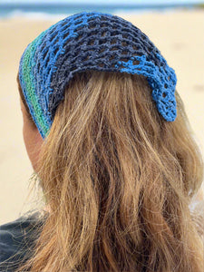 Blue crochet headband worn by a person with long blonde hair, outdoor setting