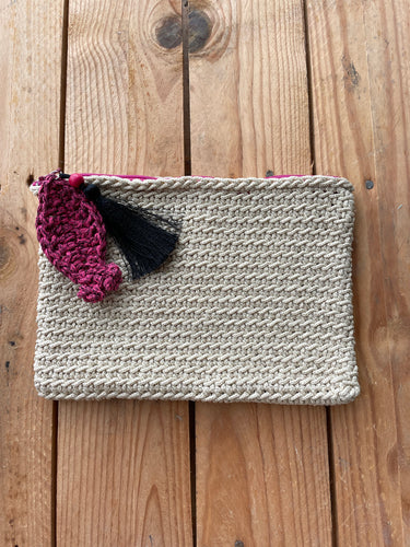 Knitted pouch with tassels on a wooden surface