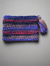 Load image into Gallery viewer, Crocheted pouch with multicolor pattern and tassel on a gray background
