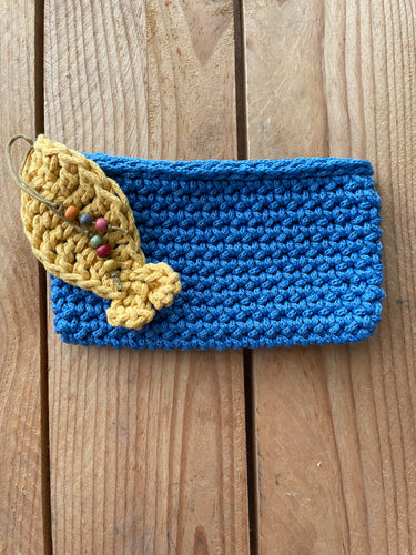 Blue knitted crochet wallet with a yellow pouch on a wooden surface