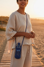 Load image into Gallery viewer, Blue crocheted bag with a bottle inside on a white background
