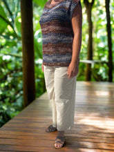 Load image into Gallery viewer, Person wearing a patterned top and light-colored pants by a poolside.
