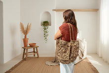 Load image into Gallery viewer, Brown crochet bag held by a person with a boho background
