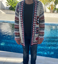 Load image into Gallery viewer, Person wearing a colorful crochet cardigan by a pool
