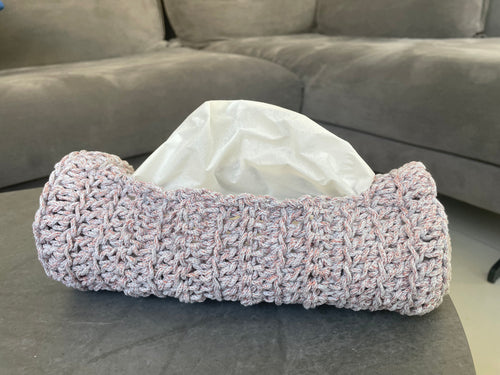 Crocheted tissue holder with tissues on a gray surface