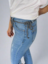 Load image into Gallery viewer, Person wearing blue jeans and a white shirt sitting on a white surface.

