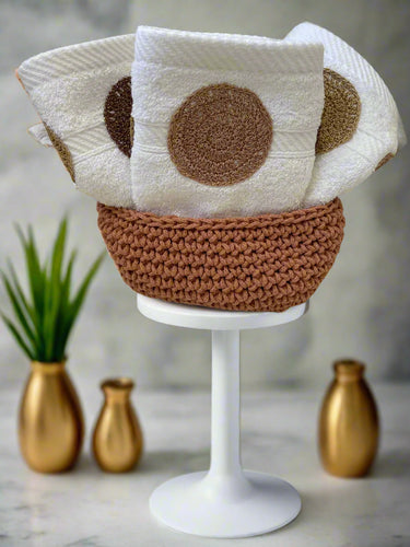 Knitted items including a white square with brown circles and a brown circular object on a neutral background