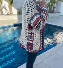 Load image into Gallery viewer, Person wearing a colorful crochet cardigan by a poolside
