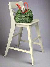 Load image into Gallery viewer, Green woven bag with red handles on a white stool against a gray background
