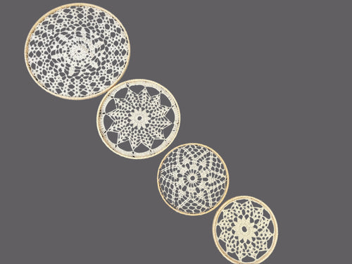 Four decorative doilies with intricate patterns on a gray background