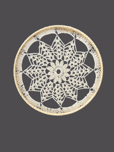 Crocheted doily on a gray background