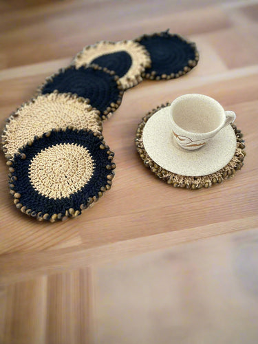 Set of crocheted coasters with a cup on a wooden surface