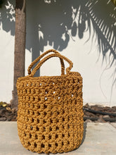 Load image into Gallery viewer, Brown woven handbag on a light surface with shadows
