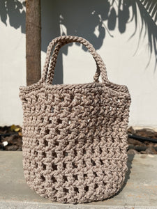 Beige crochet bag against a light background