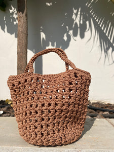 Brown woven handbag against a light background