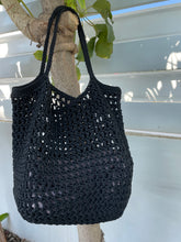Load image into Gallery viewer, Black crochet bag on a branch with a white background
